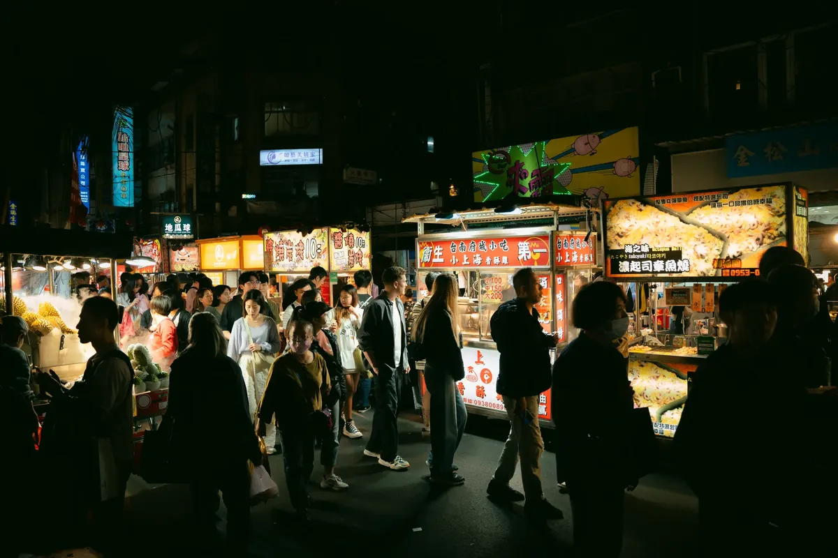 にぎやかな夜市で、さまざまな料理を提供する食料品店が並び、活気に満ちた雰囲気