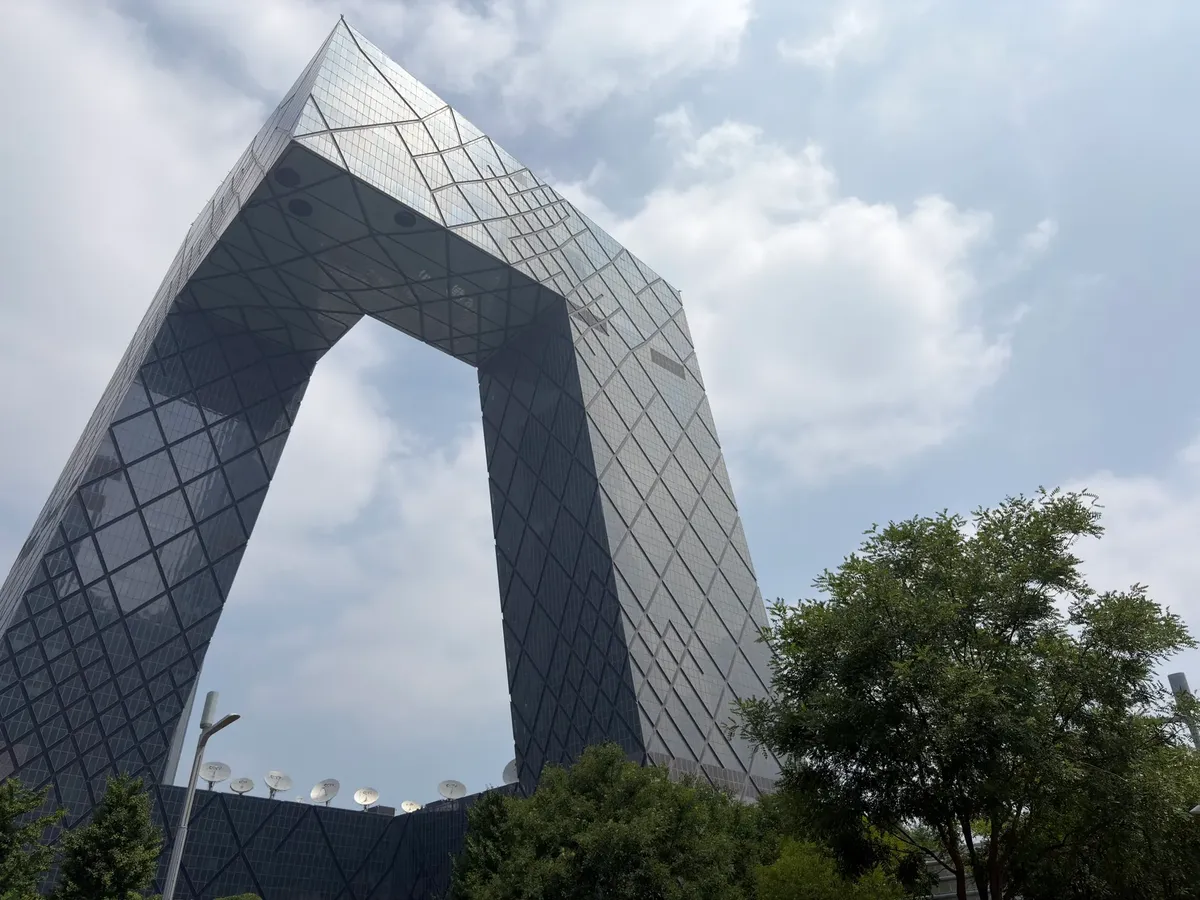 The iconic CCTV Headquarters in Beijing stands tall against a bright sky, showcasing modern architecture.